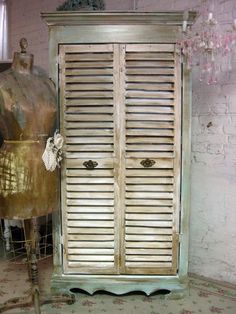 an old fashion dress on display next to a mannequin's dummy and wooden shutters