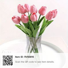 pink tulips are in a clear vase on a white tray with qr code to see them details