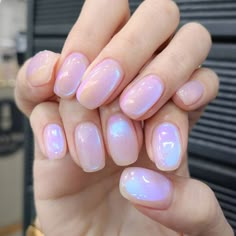 a person with pink and white nail polish holding up their hand in front of the camera