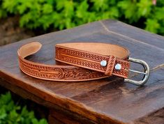 ➤Fully handmade western cowboy leather belt ➤ Stainless Steel Buckle ➤Tooled embossed design ➤Custom engraving option ➤ Single Piece Leather ➤100% full grain genuine leather ➤ Easy Snap System for Interchanging Buckles ➤ 1.5" WIDE ➤Belt thickness 3.2 mm - 1/8" thickness ➤Returns accepted within 30 days of receiving item (custom engraved beltscannot be returned) Tooled Western Floral Engraved Leather Belt for Men 100% Genuine Full Grain Cowhide with Snaps 1-1/2" WIDE Personalized Belt that serves as a great gift for your loved one. You can choose to personalize this belt, making it an Engraved Belt. This is a handmade western leather belt. Engraved Leather Western Belt, Western Style Engraved Leather Belt, Western Belt Buckles For Rodeo, Hand Tooled Leather Belts For Western-themed Events, Engraved Western Belt For Ranch, Western Leather Belts And Suspenders With Antique Buckle, Rustic Leather Belt For Rodeo, Western Style Engraved Belt For Ranch, Western Leather Belt For Western-themed Events