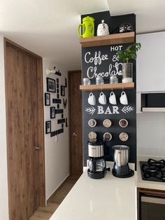 there is a coffee bar on the wall in this kitchen with white countertops and wooden shelves