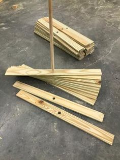 several pieces of wood sitting on top of a cement floor next to a wooden pole