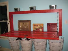 three buckets are stacked on top of each other in front of a red shelf