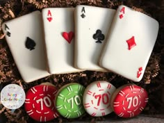 four playing cards are sitting on top of three cookies in a box with the number ten