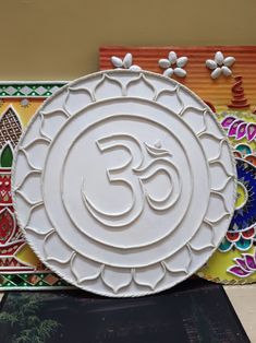 a white plate sitting on top of a table next to colorful wall paper and artwork