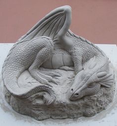 a statue of a dragon sitting on top of a rock