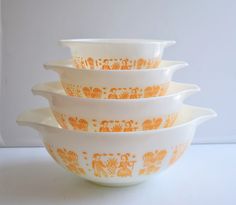 four orange and white bowls stacked on top of each other