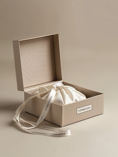 an open box with a white ribbon in it