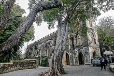 an old stone church surrounded by trees and people