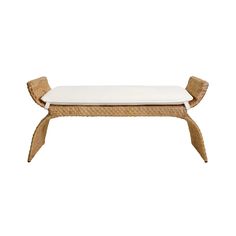 a bench made out of wicker with white cushions