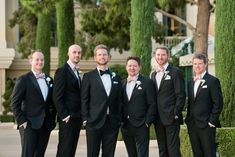 a group of men standing next to each other in tuxedos and bow ties