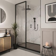 a bathroom with marble walls and flooring, a sink, mirror, and shower