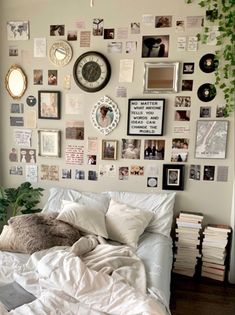 there is a bed with white sheets and pictures on the wall above it in this bedroom