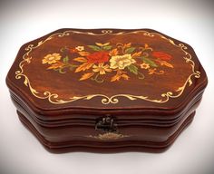 an ornate wooden box with flowers painted on it