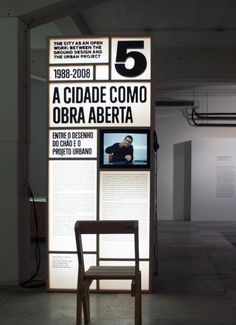 a chair sitting in front of a sign that reads 5 a cidade como obra aberta