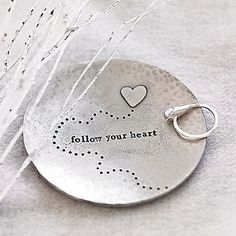 a metal disc with a heart on it that says follow your heart and is attached to the side