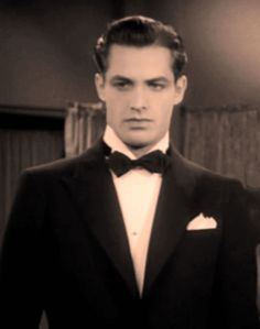 a man in a tuxedo and bow tie is looking at the camera with an intense look on his face