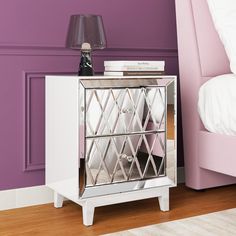 a mirrored cabinet next to a bed in a room with purple walls and wooden floors