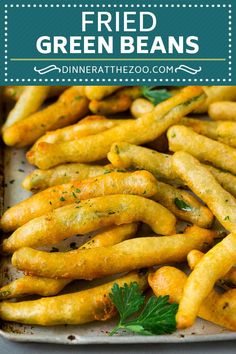 fried green beans in a pan with parsley on top and the words, fried green beans