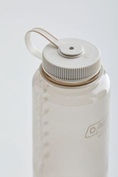 a white water bottle with a brown lid on a white surface, showing the cap and handle