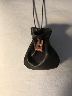 a small black purse hanging from a cord