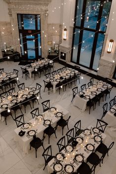 an overhead view of tables and chairs set up in a large room with tall windows