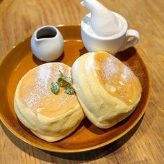 two pancakes on a plate with powdered sugar