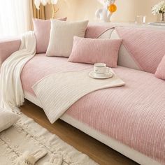 a living room with pink couches and pillows