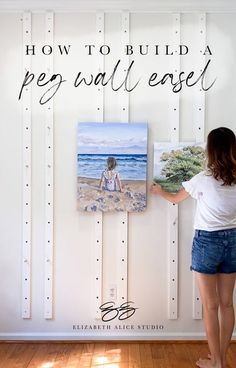 a woman standing in front of a white wall with a painting on it and the words how to build a ped - wall ease