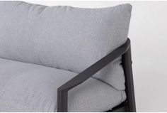 the back of a gray couch with black metal frame and grey linen pillows on it