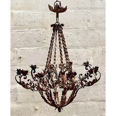 a chandelier hanging from the ceiling in front of a white brick wall