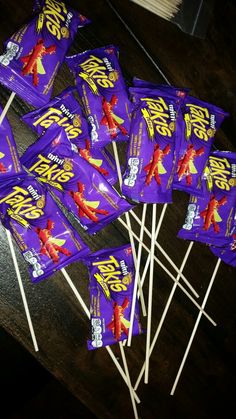 there are many bags of purple candy on the sticks with toothpicks in them