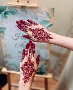 two hands with henna tattoos on their palms