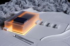 an architectural model is shown on top of a white surface with light coming from it