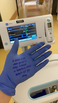 a person in blue gloves is holding up a machine with writing on it's screen