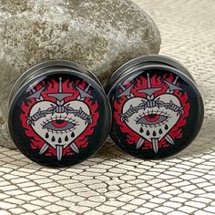 two black and red grinders sitting on top of a rock next to each other