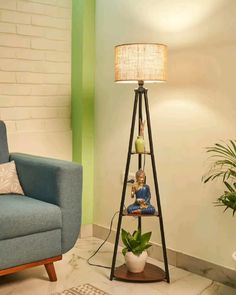 a living room with a blue chair and a lamp on the floor next to it