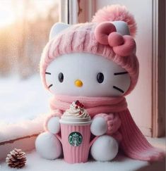 a hello kitty doll holding a starbucks cup in the snow with a pink scarf around it's neck