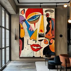 an abstract painting hangs in the middle of a room with black chairs and large windows