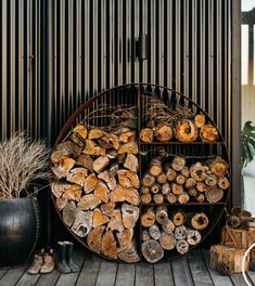 a rack filled with lots of logs on top of a wooden floor next to potted plants