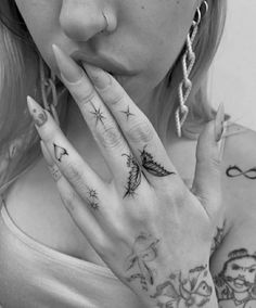 a woman with tattoos on her hands and fingers