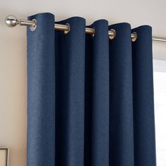 a blue curtain hanging on the side of a window