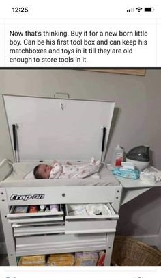 a baby is laying in an open box on top of a table with other items