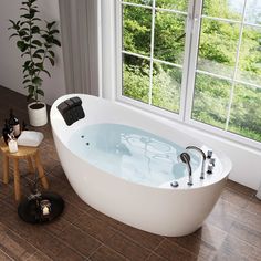 a large white bath tub sitting in front of a window next to a wooden stool