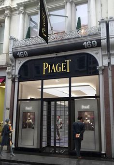 two people are standing in front of a storefront with the word piagett on it