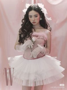 a woman in a pink dress and white gloves holding a teddy bear on her chest