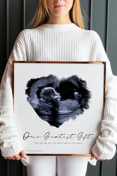 a woman holding up a poster with the words our greatest gift