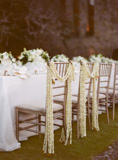 the table is set with white linens and gold tassels, along with flowers