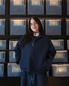 a woman standing in front of stacks of cd's with her hands on her hips