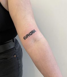 a woman's arm with the word euphora tattooed on it